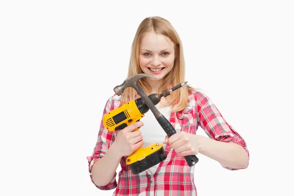 Frau hält Elektroschrauber und Hammer in der Hand — Stockfoto