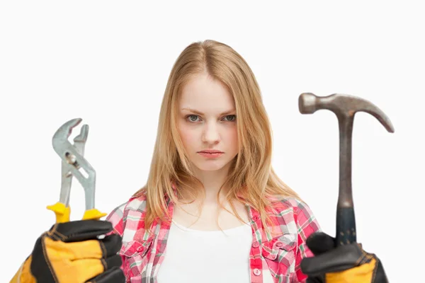 Ernsthafte Frau mit Hammer und Schraubenschlüssel — Stockfoto