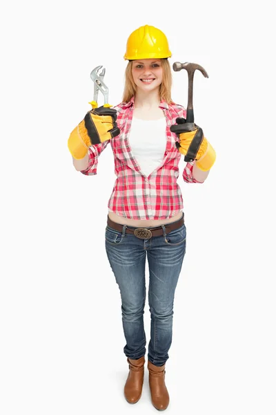 Frau trägt Schutzhelm und hält Werkzeug in der Hand — Stockfoto