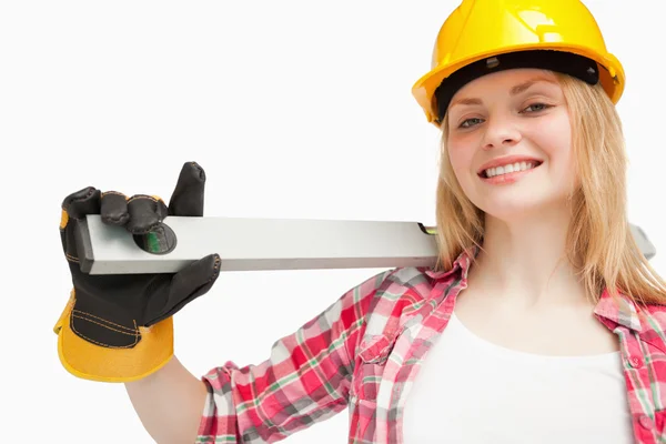 Young woman holding a spirit level — Stockfoto