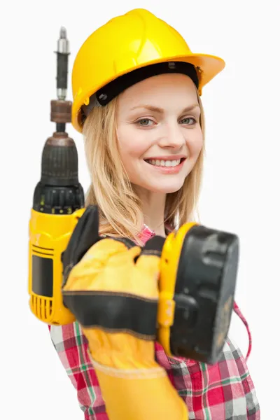 Gülümseyen bir elektrikli tornavida tutan kadın — Stok fotoğraf