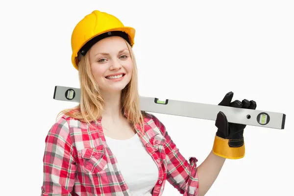 Mulher sorridente segurando um nível de espírito — Fotografia de Stock