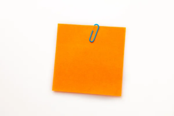 Orange adhesive note with a paperclip Stock Image