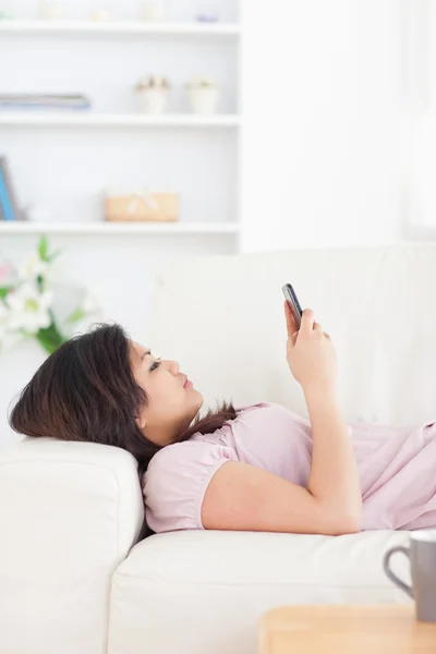 Mujer descansando en un sofá blanco — Foto de Stock