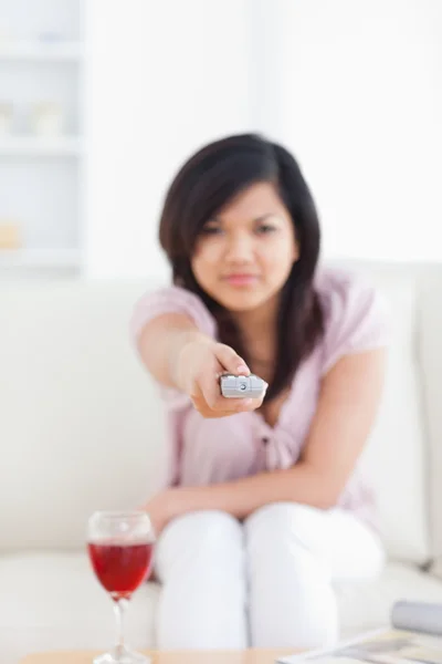 Blurred woman holding a television remote — Stock Photo, Image