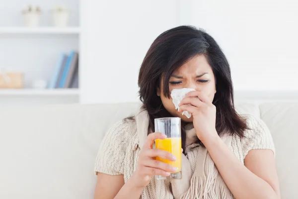 Mujer estornuda bebiendo un vaso de jugo de naranja —  Fotos de Stock