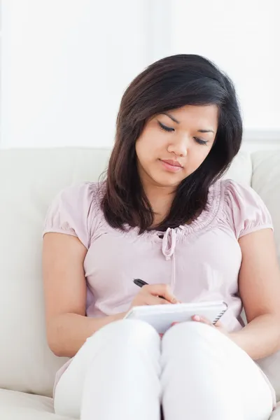 Kobieta siedzi na kanapie podczas pisania na notebooka — Zdjęcie stockowe