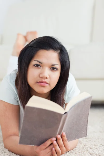 Kobieta trzyma książkę leżąc na podłodze — Zdjęcie stockowe