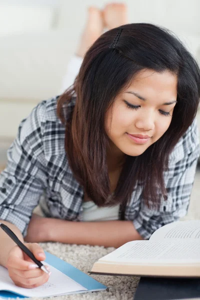 Mulher escrevendo em um caderno e lendo um livro — Fotografia de Stock