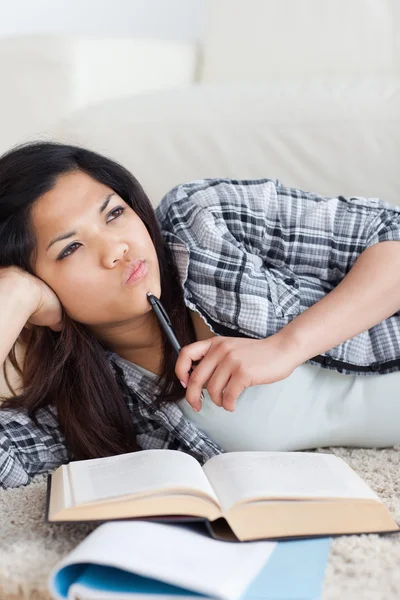 Närbild av en kvinna som tänker medan du håller en penna och en bok — Stockfoto