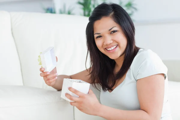 Mujer sonriendo con una caja de regalo abierta en sus manos — Foto de Stock