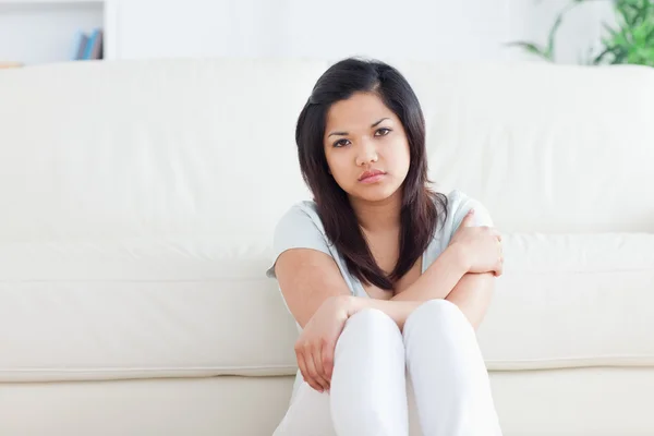 Vrouw zitten voor een bank Stockfoto