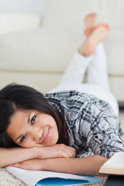 Woman crossing her legs and her arms as she lays on the floor — Stock Photo, Image