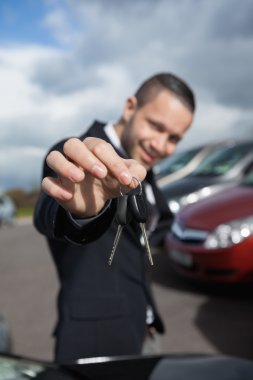 Happy businessman holding car keys clipart