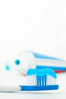 Toothpaste next to a toothbrush clipart