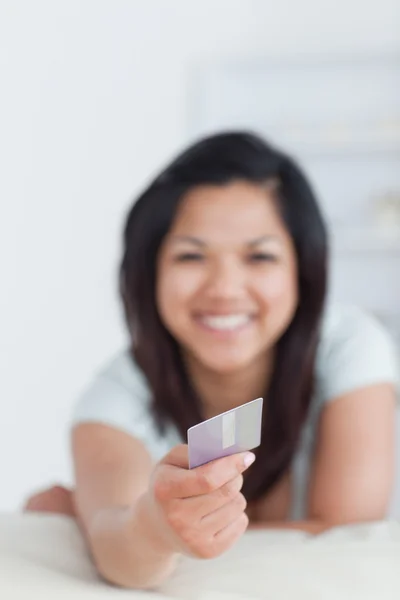 Mujer sonriente sosteniendo una tarjeta de crédito — Foto de Stock