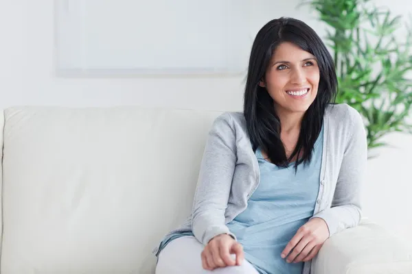 Femme souriante relaxante sur un canapé — Photo