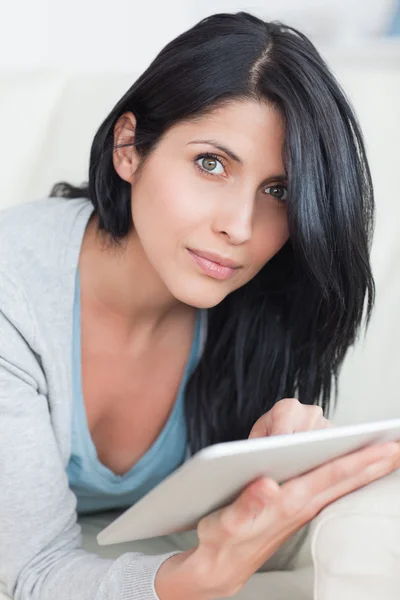 Close up van een vrouw op een bank te leggen tijdens het typen op een Tablet PC — Stockfoto