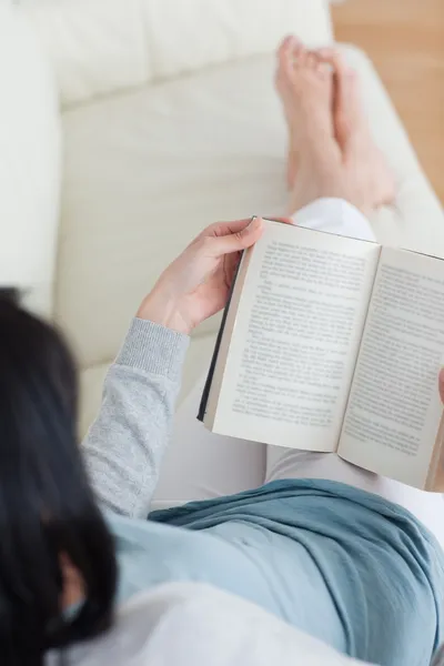 Mulher lendo um livro com as pernas cruzadas — Fotografia de Stock