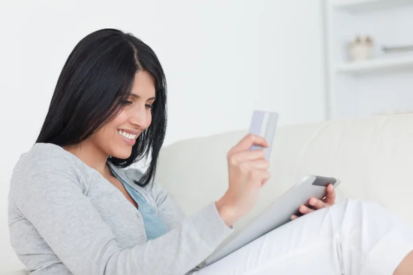 Mulher segurando um cartão e um tablet — Fotografia de Stock