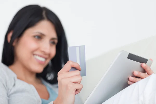 Mujer sosteniendo una tableta táctil y una tarjeta de crédito — Foto de Stock