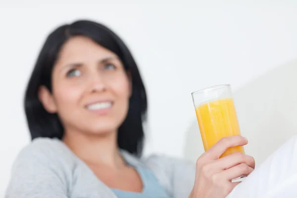 Kvinna som håller i ett glas apelsinjuice — Stockfoto