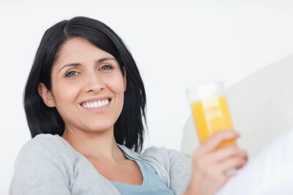 Mulher sorridente segurando um copo de suco — Fotografia de Stock