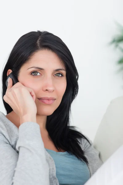 Woman phoning while resting on a couch — Stock Photo, Image