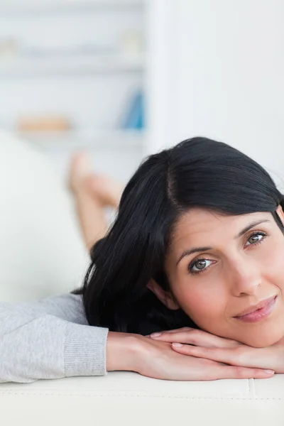 Primer plano de una mujer apoyando la cabeza en un sofá — Foto de Stock