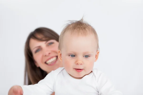 Smiling brunette woman holding her cute baby — Stock Photo, Image