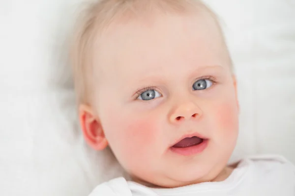 Schattige baby liggen tijdens het openen van haar mond — Stockfoto