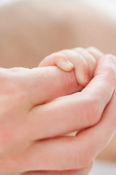 Mão segurando a mãozinha de um bebê — Fotografia de Stock