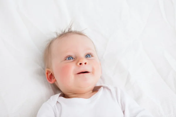 Niedliches kleines Mädchen auf einer Decke liegend — Stockfoto