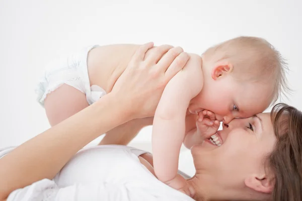 Glad mamma håller sin dotter liggande — Stockfoto