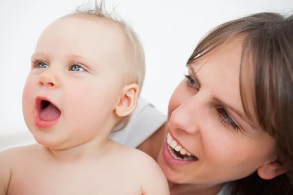 Bebê bonito abrindo a boca enquanto está segurado por sua mãe — Fotografia de Stock
