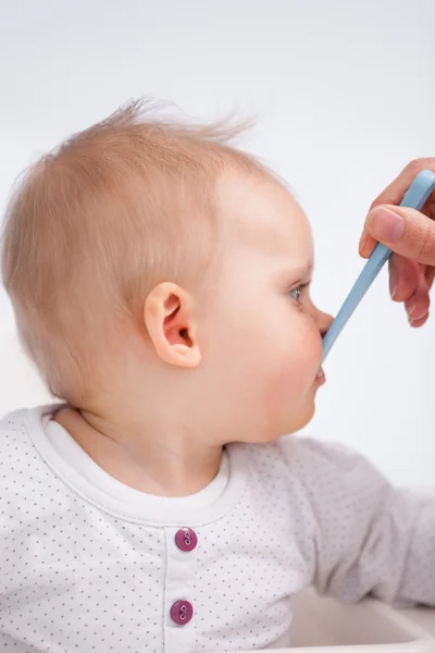 Carino mangiare bambino con un cucchiaio — Foto Stock