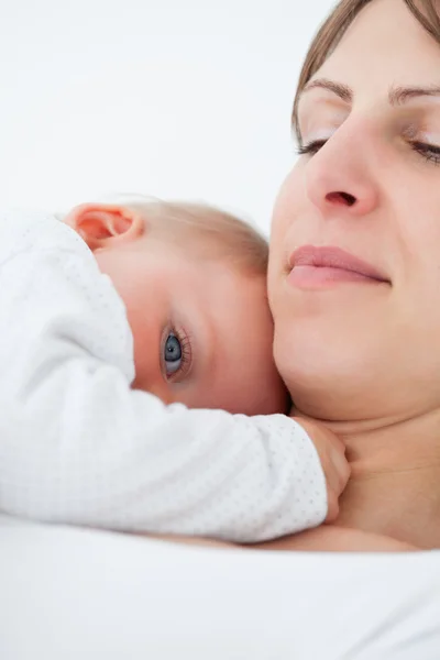Vreedzame baby liggend op de borst van haar moeder — Stockfoto