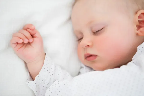 Bebé tranquilo acostado en una cama mientras duerme — Foto de Stock