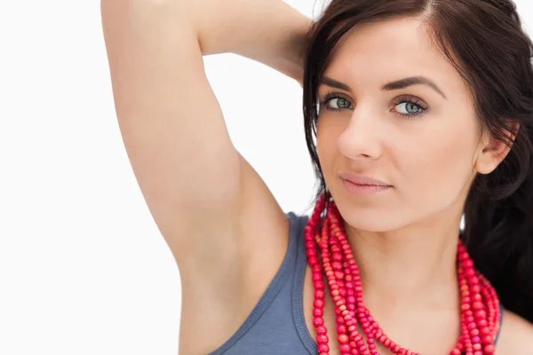 Femme aux yeux bleus posant avec un collier de perles rouges — Photo