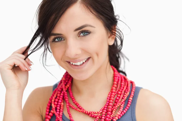 Femme aux yeux bleus souriant avec un collier de perles rouges — Photo