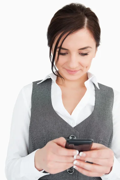 Smiling young businesswoman text-messaging — Stock Photo, Image