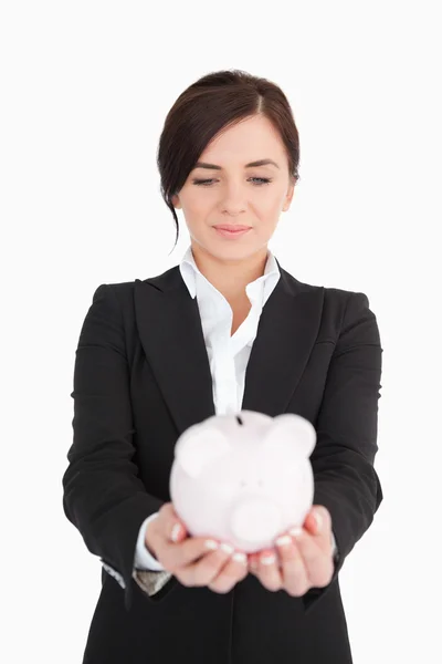 Mulher de negócios olhando para um porquinho-banco — Fotografia de Stock