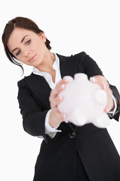 Woman in black suit emptying a piggy bank — Stock Photo, Image