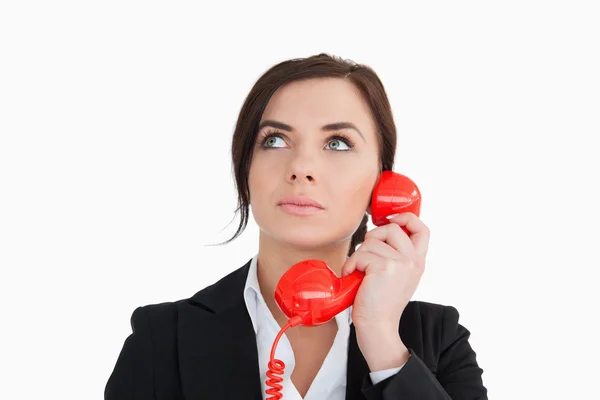 Mujer de traje usando un teléfono de línea roja — Foto de Stock