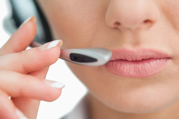 Primer plano de la boca de una mujer de negocios hablando con auriculares — Foto de Stock