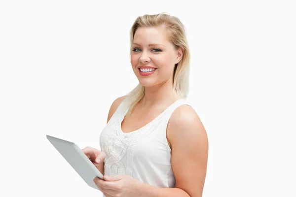 Vrolijke blonde vrouw die houdt van haar tablet-pc — Stockfoto