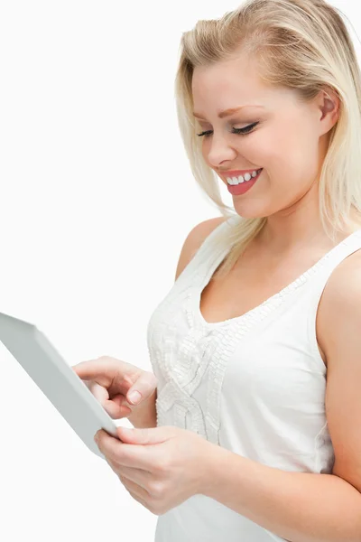 Mulher loira de pé enquanto usa seu computador tablet — Fotografia de Stock