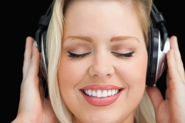Veselá žena zavřela oči při poslechu hudby — Stock fotografie