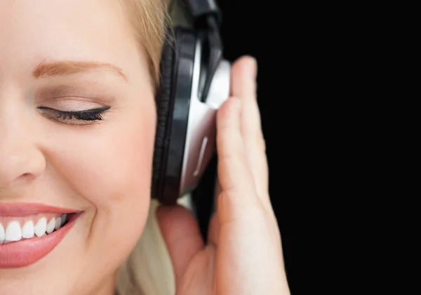 Mulher alegre fechando os olhos enquanto ouve música — Fotografia de Stock