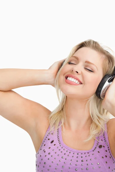 Mujer rubia inclinando la cabeza mientras escucha música — Foto de Stock